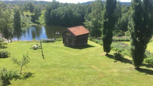 an aerial view of a cabin in a field with a lake at Stort härbre in Gagnef