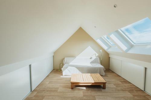 una camera mansardata con letto e tavolo di Maison de vacances à proximité de la plage a Saint-Pabu