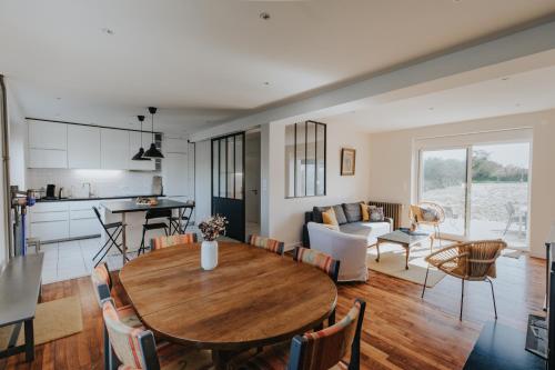 Il comprend une cuisine et un salon avec une table en bois. dans l'établissement Maison de vacances à proximité de la plage, à Saint-Pabu