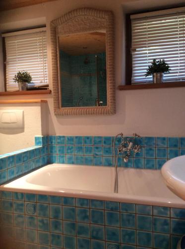 a bathroom with a bath tub with blue tiles at Beautiful Family Chalet in the heart of Inneralpbach in Inneralpbach