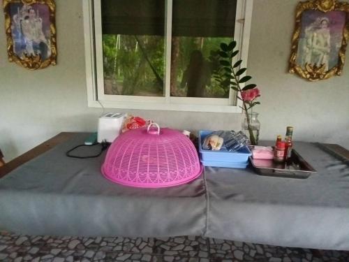 een roze hoed bovenop een tafel bij Chonnapha Homestay in Ban Thai Chang