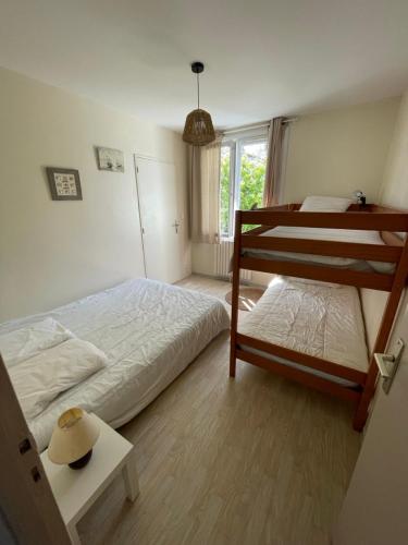 - une chambre avec 2 lits superposés et un chapeau sur une table dans l'établissement Le Beau Repaire de Jean, à Beaurepaire