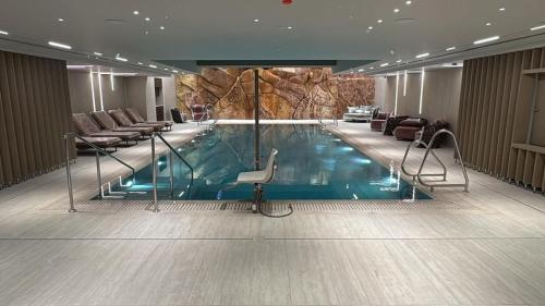 - une piscine dans une chambre d'hôtel avec des chaises et des plaques de cuisson dans l'établissement GOLDEN SAND Suite, à Eilat
