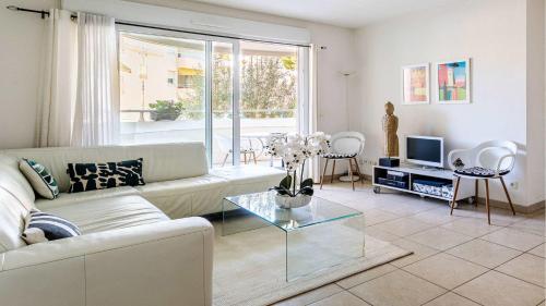 un salon avec un canapé et une télévision dans l'établissement B014 Spacieux 2 chambres piscine parking 4min plage, à Cannes