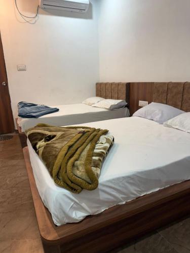 two beds in a room with a blanket on them at Shree Banke Bihari Place in Khātu