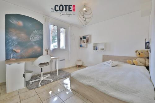 - une chambre avec un lit, un bureau et un ours en peluche dans l'établissement Villa les Vagues, à Carry-le-Rouet