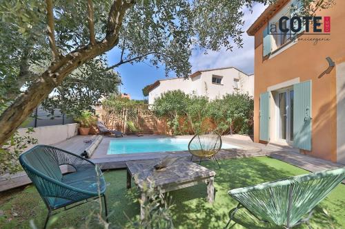 une cour avec une piscine, 2 chaises et une table dans l'établissement Villa les Vagues, à Carry-le-Rouet