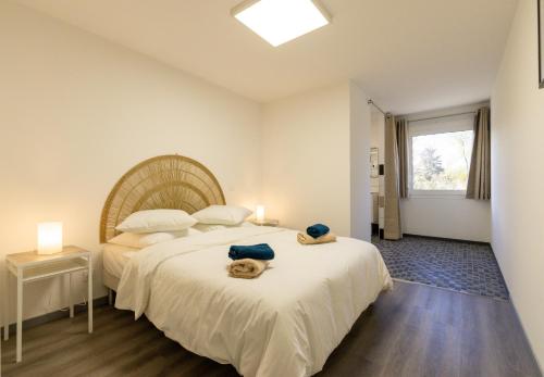 une chambre avec un grand lit avec deux serviettes dessus dans l'établissement L'Ilot Narossais 10 - idéal curiste - clim - proche Dax, à Narrosse