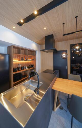 a kitchen with a stainless steel sink and a table at L&R RUSUTSU - Vacation STAY 05019v in Kimobetsu
