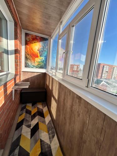 a room with windows and a checkered floor at Уютная 1 комнатная квартира, в самом сердце Костаная in Kostanay