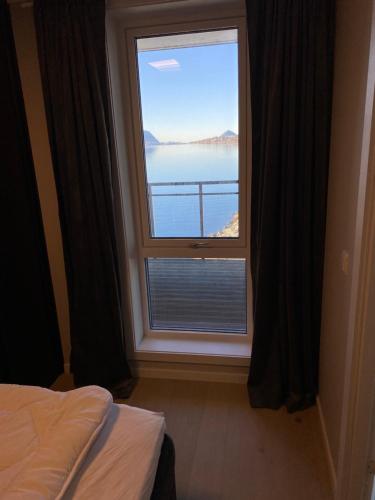 a bedroom with a window with a view of the water at Ny leilighet i Ålesund med fantastisk utsikt in Ålesund