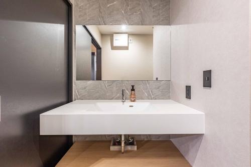 a white sink in a bathroom with a mirror at L&R RUSUTSU - Vacation STAY 05019v in Kimobetsu
