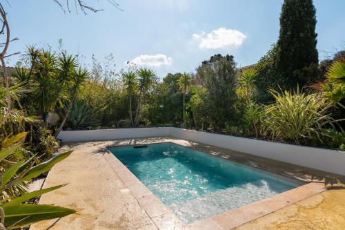 une piscine au milieu d'un jardin dans l'établissement Villa Nouméa, à Cases-de-Pène