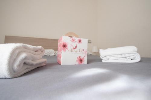 a book sitting on top of a bed with towels at Trilocale Ospedale Civile 6 Via Costalunga in Brescia