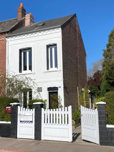 une clôture blanche devant une maison blanche dans l'établissement La Chambre Claire, à Ponts-et-Marais