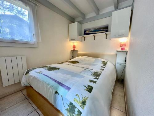 a small bedroom with a bed and a window at Maison Cosy Clim Jardin Proche Océan in Lacanau