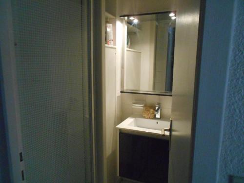 a bathroom with a sink and a mirror and a shower at Maison Cosy Clim Jardin Proche Océan in Lacanau