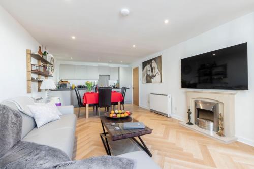 a living room with a white couch and a fireplace at Thornton House Town Centre Free Car Park in Cheltenham