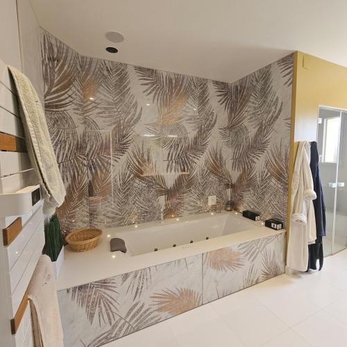 une salle de bain avec une baignoire avec un papier peint tropical dans l'établissement Villa de prestige Loire Valley, à Saint-Avertin