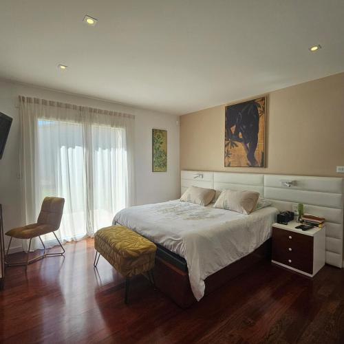 une chambre avec un grand lit et une chaise dans l'établissement Villa de prestige Loire Valley, à Saint-Avertin