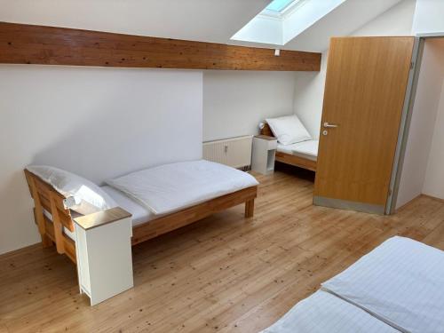 a bedroom with two beds and a wooden door at Köpplmühle Apartment in Freistadt
