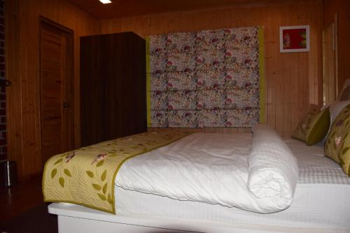 a bedroom with a large bed with a yellow blanket at Megha Resort & Villas, Dehradun-Where Nature Pampers You in Dehradun