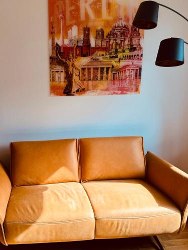 a brown leather couch in a living room with a painting at Aufladen & Entspannen im Senfzimmer mit Balkon in Gerwisch