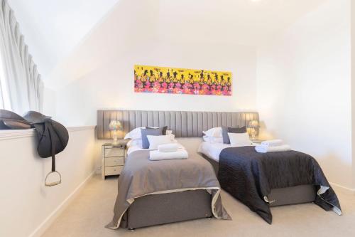 a bedroom with two beds and a painting on the wall at Thornton House Town Centre Free Car Park in Cheltenham