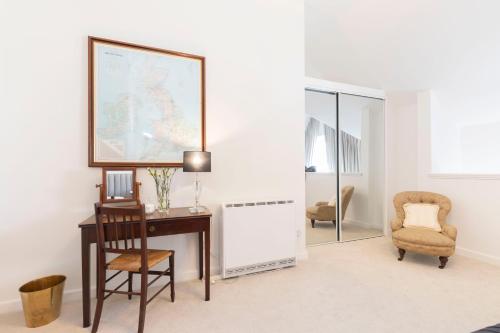 a room with a desk and a chair and a mirror at Thornton House Town Centre Free Car Park in Cheltenham