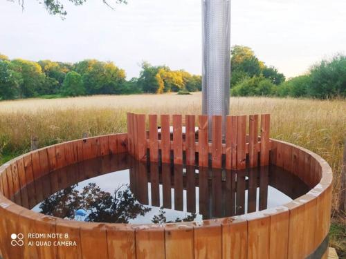 a bird bath in a wooden fence with a pond at Clos de l'Isop, le village d'hébergements insolites in Saint-Martial-sur-Isop