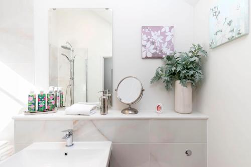 a bathroom with a sink and a mirror at Thornton House Town Centre Free Car Park in Cheltenham