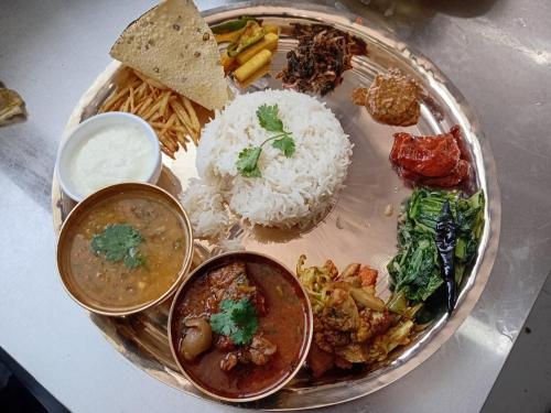 a plate of food with rice and different types of food at kotbari hotel in Yārsa