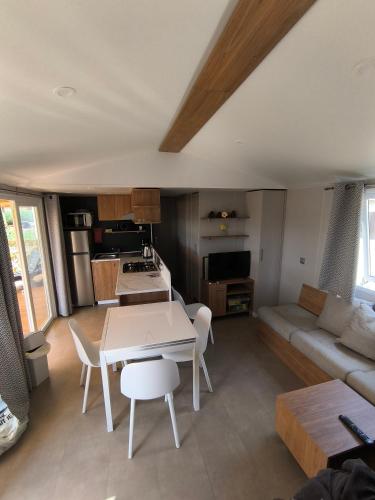 une cuisine et un salon avec une table et un canapé dans l'établissement Mobil-Home 45 m2 camping le Mar Estang 4 étoiles, à Canet