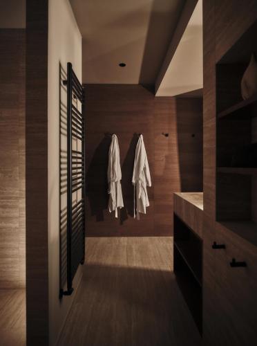 a bathroom with wooden walls and a walk in closet at Casa Cook Madonna - Adults Only in Madonna di Campiglio