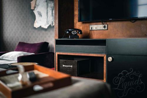 a living room with a fireplace and a tv at Stora Hotellet; BW Premier Collection in Umeå