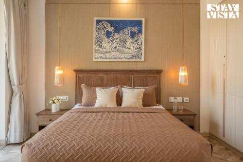 a bedroom with a large bed with two tables at StayVista at Casa Vida Zeo with BBQ, Pool, WiFi in Assagao