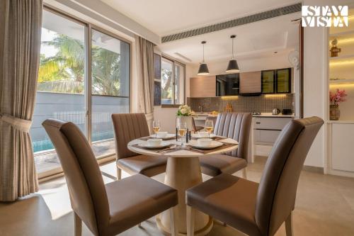 a kitchen and dining room with a table and chairs at StayVista at Casa Vida Zeo with BBQ, Pool, WiFi in Assagao