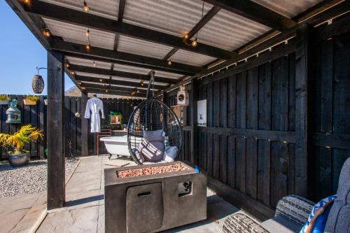 an outdoor patio with a grill and a chair at Appin Holiday Homes -Caravans, Lodges, Shepherds Hut and Train Carriage stays in Appin