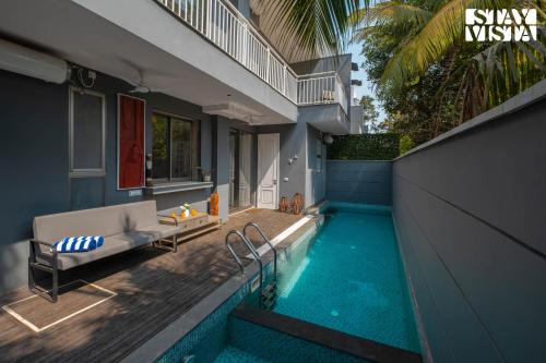 a house with a swimming pool next to a house at StayVista at Casa Vida Zeo with BBQ, Pool, WiFi in Assagao