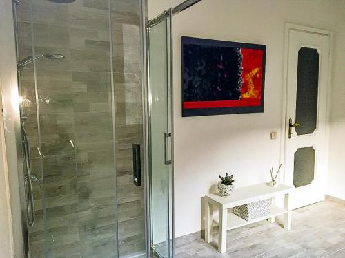 a bathroom with a glass shower with a table at Villa Giuliana in Cannobio