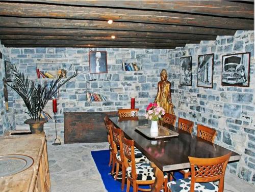 a room with a stone wall with a table and chairs at Chalet Cabbio in Muggio