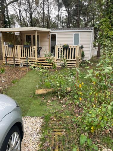 une petite maison avec une clôture en bois devant elle dans l'établissement Au petit paradis, à Camiers