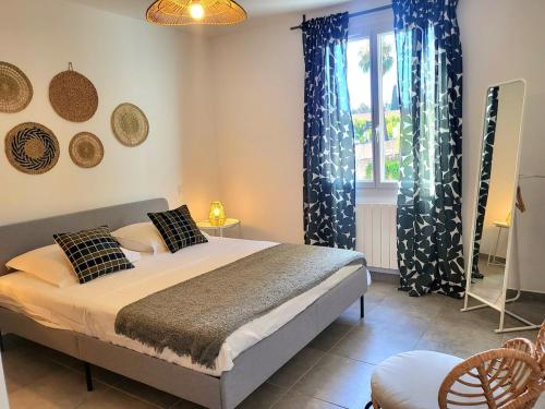 - une chambre avec un lit doté de rideaux bleus et d'une fenêtre dans l'établissement T2 rénové jardin et parking, à Hyères