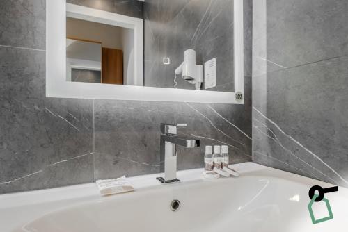 a bathroom with a white sink and a mirror at HOTIDAY Room Collection - Celle Ligure in Celle Ligure