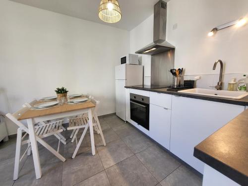- une cuisine avec une petite table et un évier dans l'établissement T2 rénové jardin et parking, à Hyères