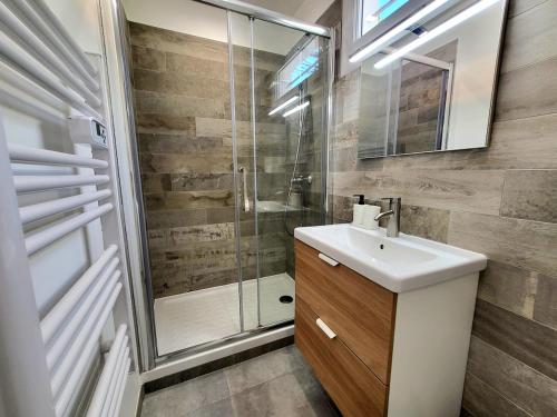 une salle de bain avec un lavabo et une douche dans l'établissement T2 rénové jardin et parking, à Hyères