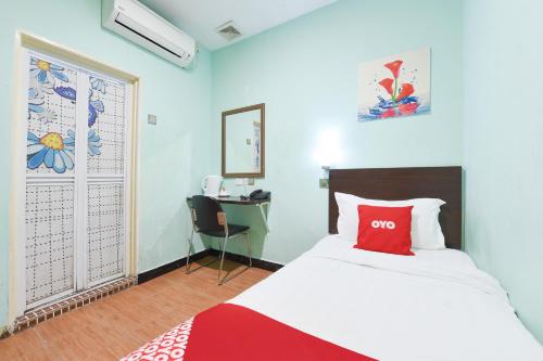 a bedroom with a bed and a desk and a window at Danceter Destiny Riverside Hotel in Kota Bharu