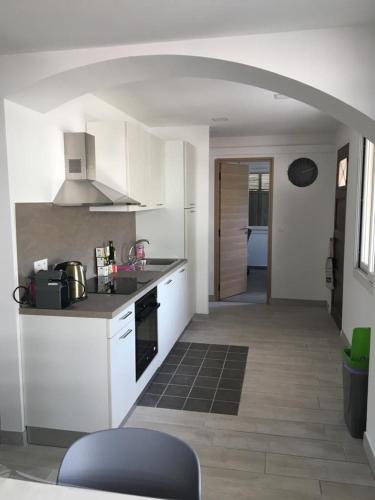 une cuisine avec des armoires blanches et un four à plaques de cuisson dans l'établissement Superbe Appartement Familial, à Cannes