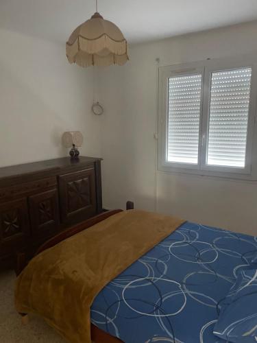 une chambre avec un grand lit et deux fenêtres dans l'établissement Maison à 13 minutes de la plage, à Saleilles