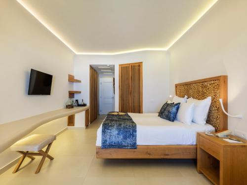 a hotel room with a bed and a desk at Anax Resort and Spa in Agios Ioannis Mykonos